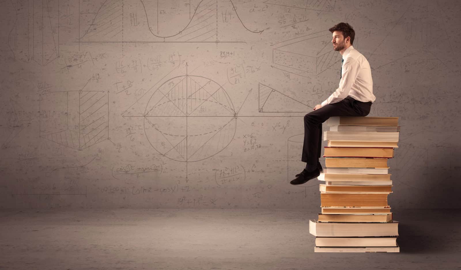 actuarial student sitting on books - Actuarial Exam Study Techniques